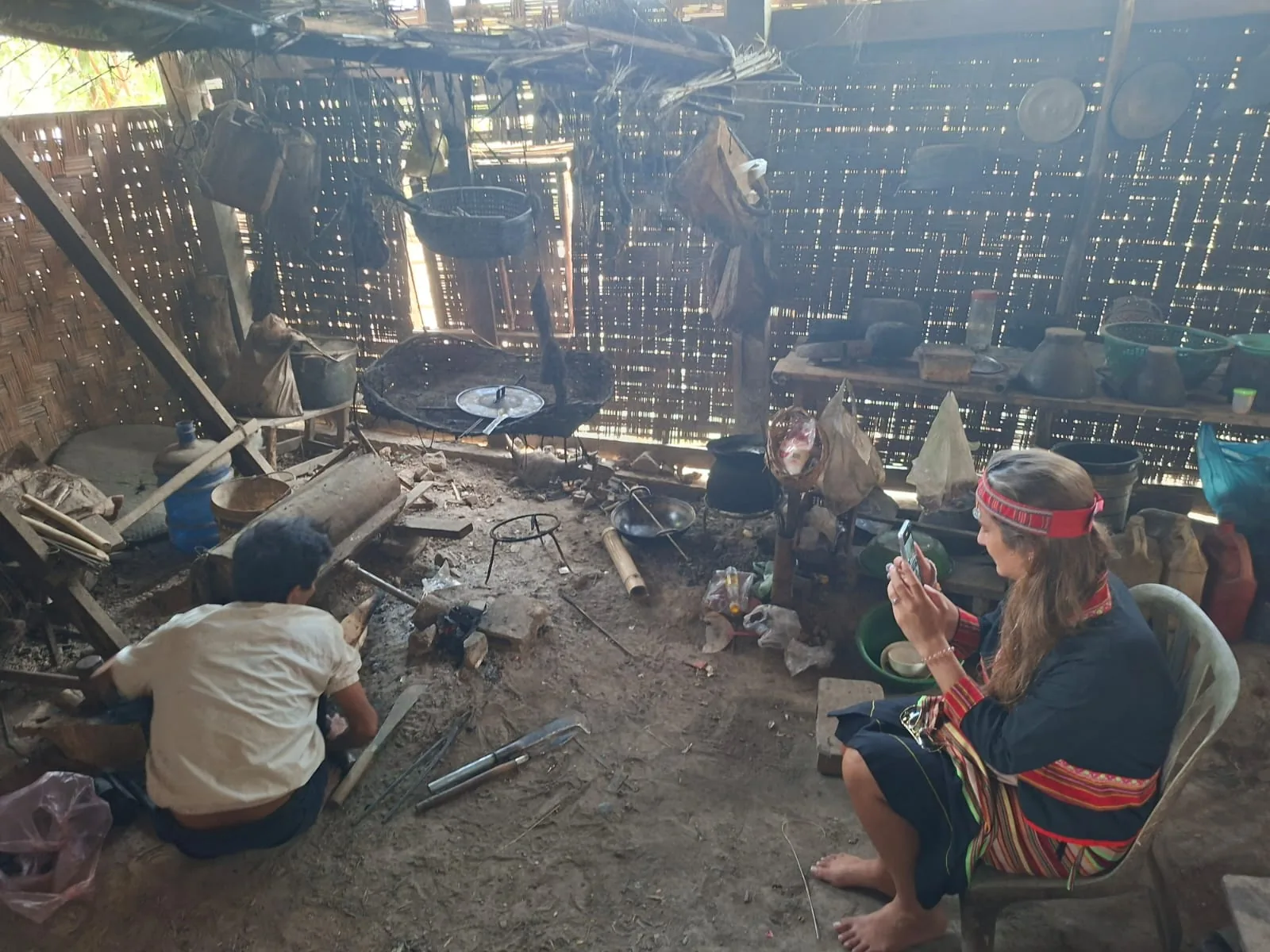 Traditional Khmu blacksmith working by the fire near Vang Vieng